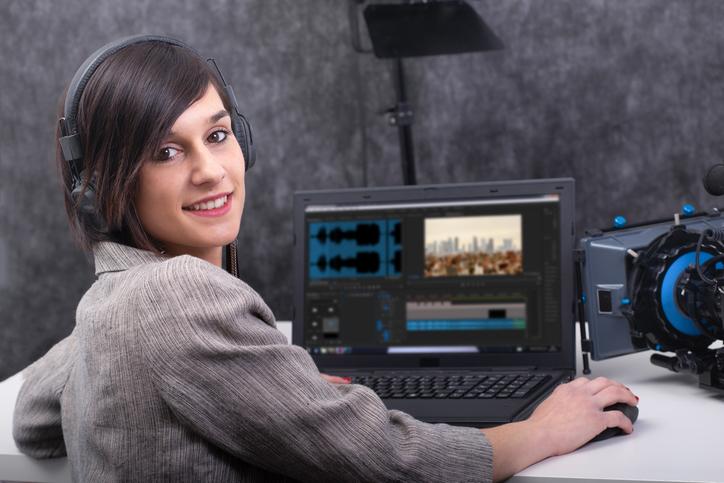 smiling young woman video editor working in studio a smiling young woman video editor working in studio